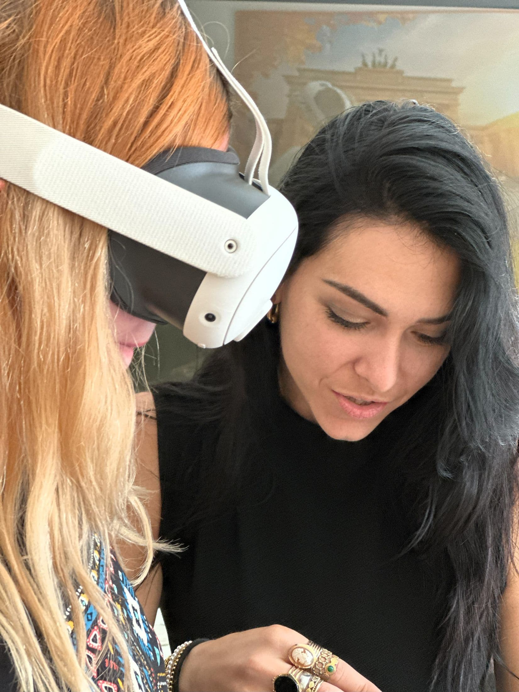 A teacher helps a colleague with the headset controller