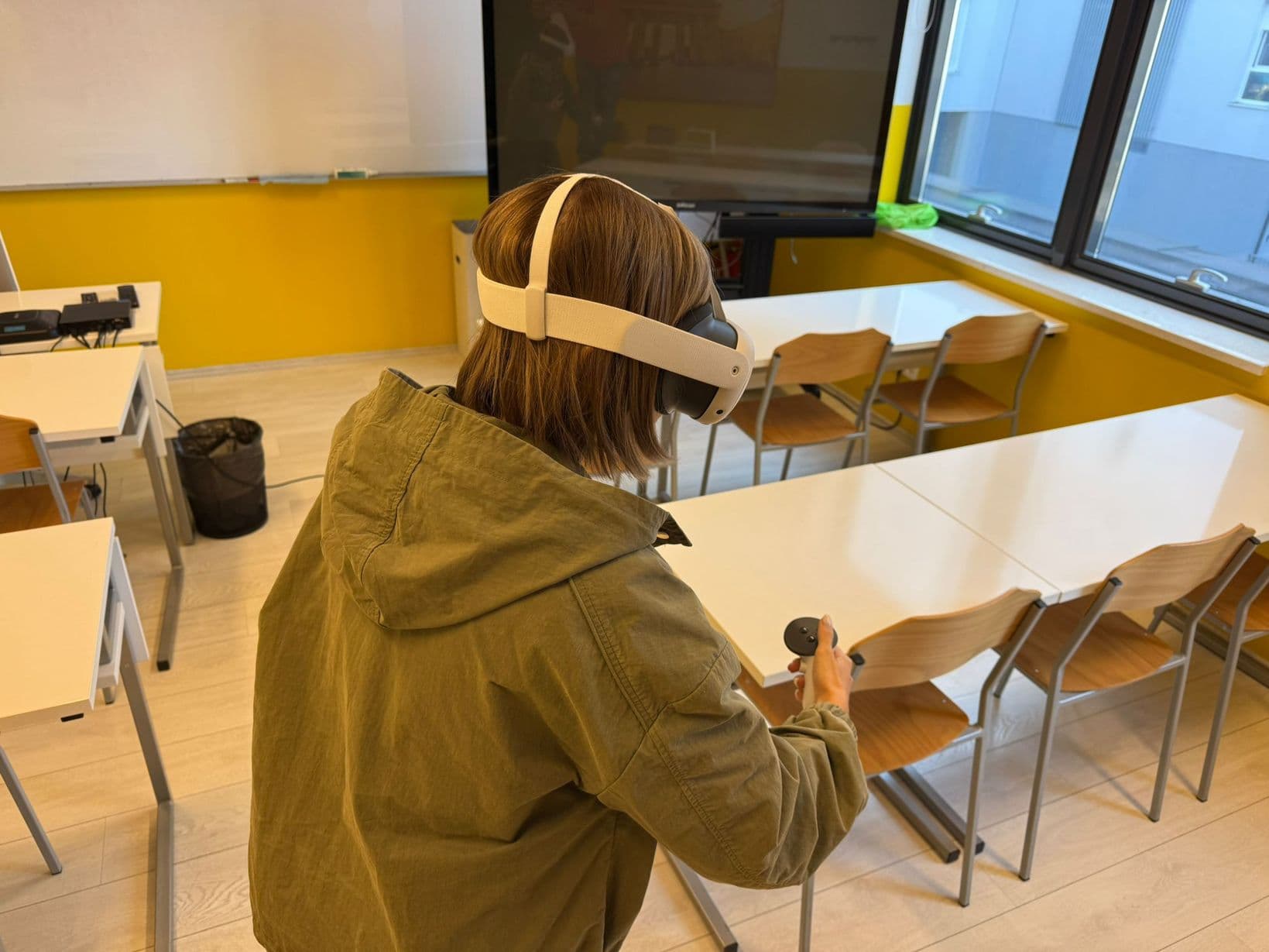 A learner in a VR headset moving around a classroom